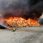 Servicios de emergencia trabajan en la extinción del incendio declarado en el exterior de una nave en Cehegín
