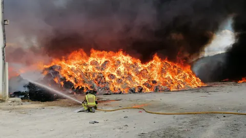 Servicios de emergencia trabajan en la extinción del incendio declarado en el exterior de una nave en Cehegín