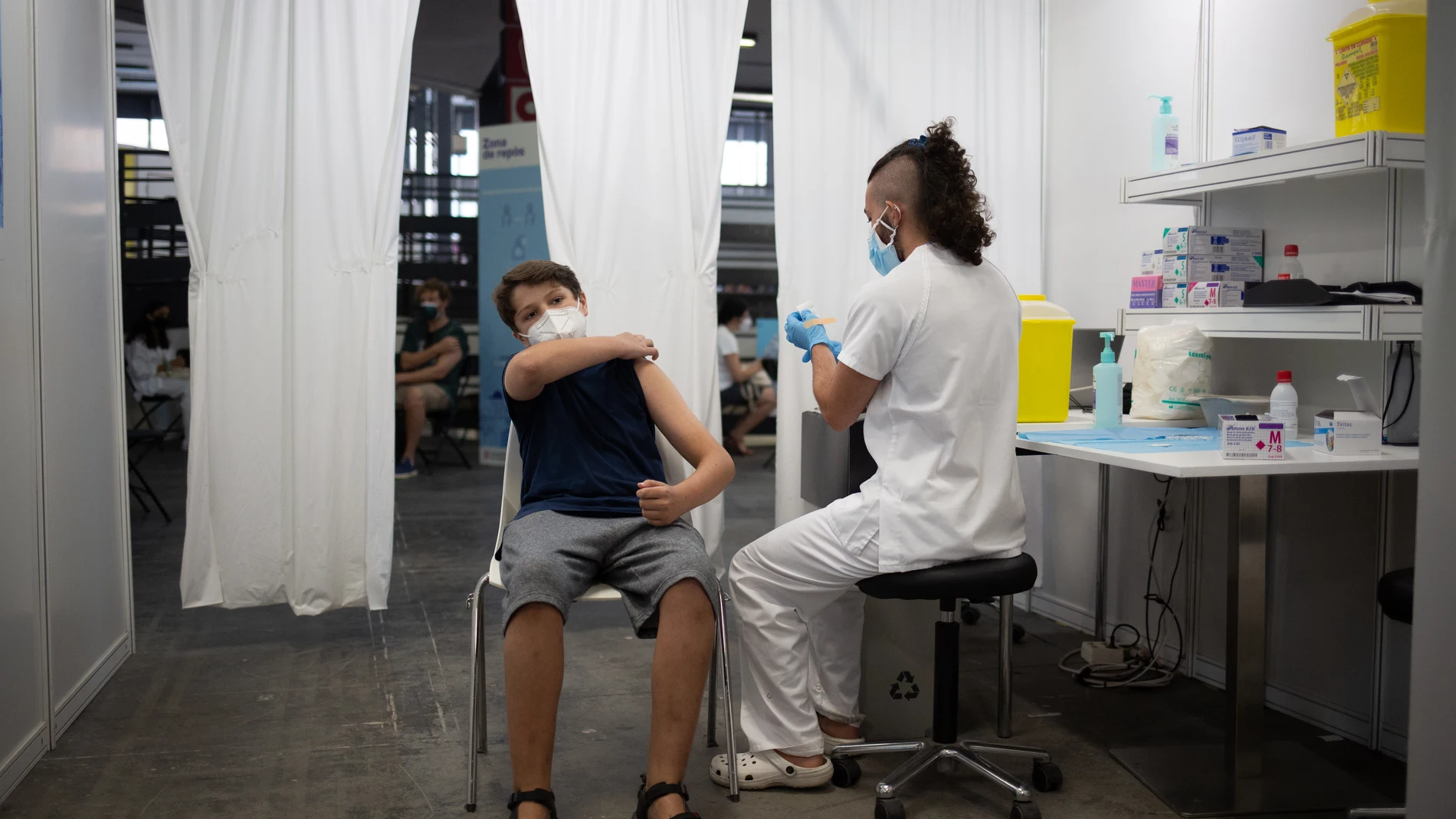 Un adolescente recibe la vacuna contra el Covid-19 en el recinto de Montjuïc de Fira de Barcelona, a 4 de agosto de 2021, en Barcelona, Catalunya, (España). El dispositivo, puesto en marcha este miércoles para los jóvenes de entre 12 y 15 años tal y como anunció ayer el president de la Generalitat, tiene como objetivo inmunizar a alrededor de 300.000 menores de esas edades. Según los datos facilitados el pasado martes por Salut, un total de 4.568.785 personas que viven en la región ya tienen la pauta completa de vacunación y más de 5 millones (5.108.452) han recibido la primera dosis.Las presentes imágenes han sido proporcionadas por EUROPA PRESS y únicamente podrán ser utilizadas para ilustrar la noticia que la acompañan. En ningún caso se podrá hacer uso de dichas imágenes acompañando cualquier otra noticia.04 AGOSTO 2021;VACUNACIÓN;CATALUÑA;CATALUNYA;BARCELONA;FIRA DE BARCELONADavid Zorrakino / Europa Press (Foto de ARCHIVO)04/08/20