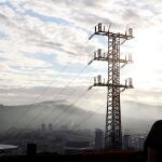 Una persona observa el cableado con el que red eléctrica transporta la energía sobre la ciudad de Bilbao | Fuente: EFE/LUIS TEJIDO