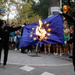 Dos encapuchados queman una bandera de la Unión Europea durante una manifestación con motivo de la última Diada