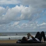 Un hombre lee un libro en la playa de San Sebastián