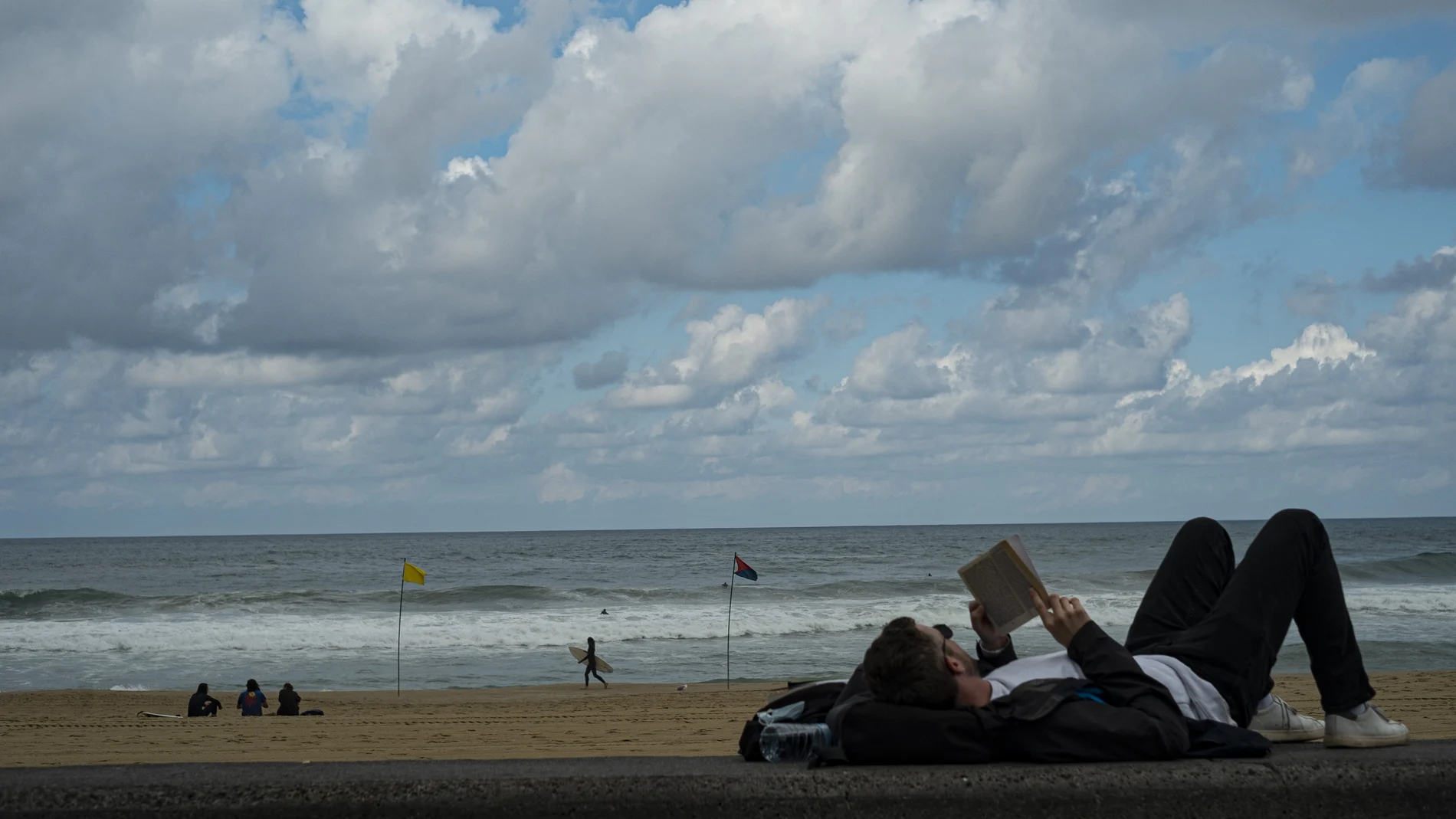 Un hombre lee un libro en la playa de San Sebastián