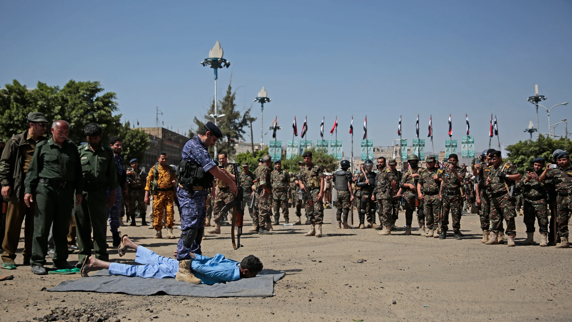 Uno de los condenados por el asesinato de Saleh al-Samad yace en el suelo esperando el tiro por la espalda