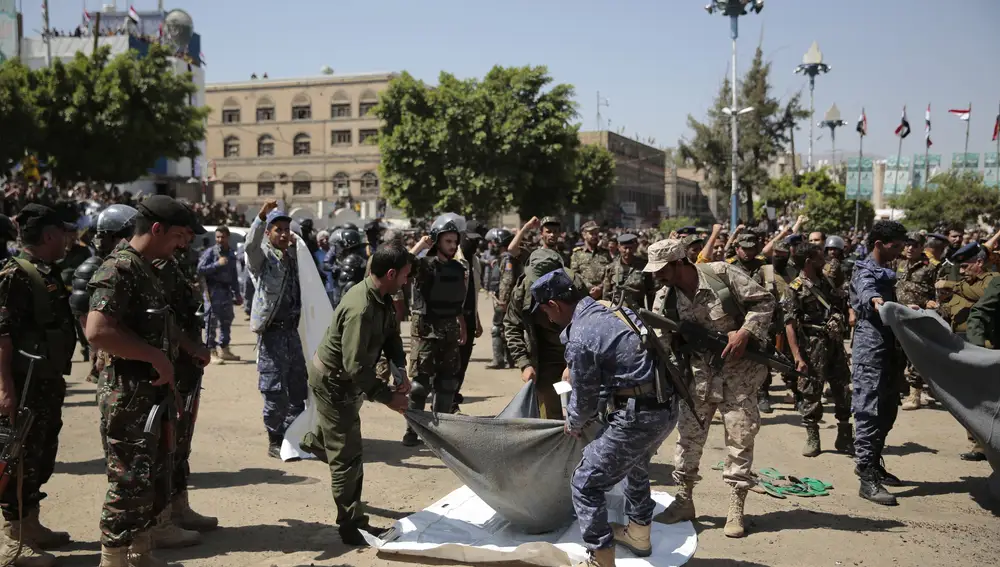 Policías yemeníes se llevan el cuerpo de uno de los ejecutados en Sana