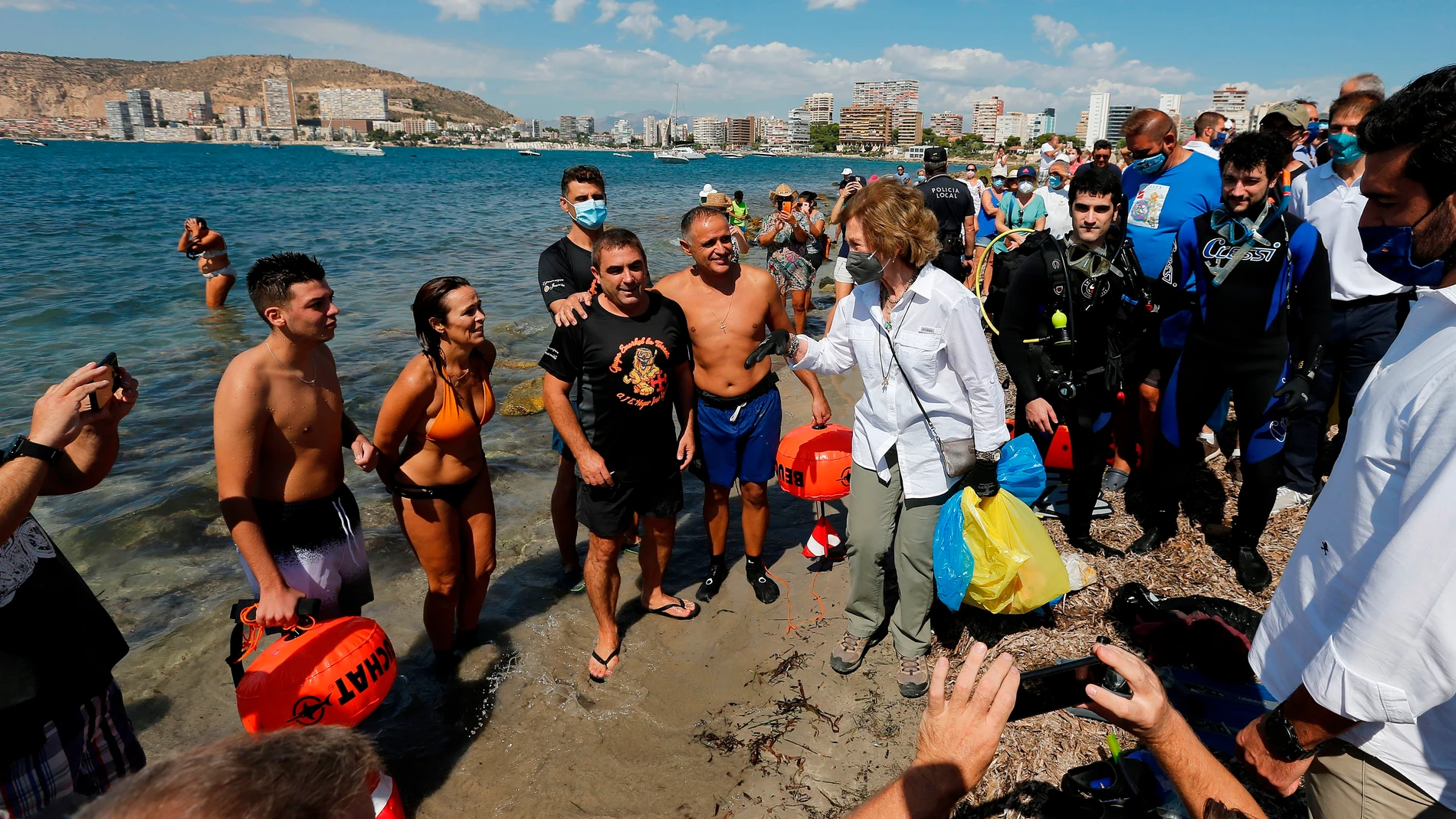 La Reina Sofía (c) saluda a los bañistas este sábado durante su participación en una recogida de residuos en el espigón de la playa de la Almadraba de Alicante, en el marco de una campaña promovida por SEO/Birdlife y Ecoembes con motivo del día internacional de la Limpieza de Playas.