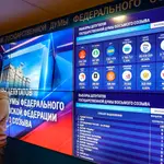 Un hombre junto a un panel con los resultados de las elecciones legislativas en Rusia