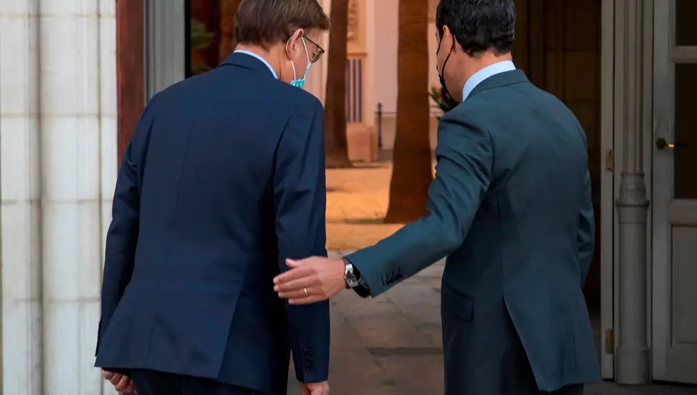 El presidente de la Junta de Andalucía, Juanma Moreno, del PP, (d), y el de la Generalitat Valenciana, Ximo Puig, del PSOE (i), tras posar ante la fachada del Palacio de San Telmo. EFE/ Raúl Caro