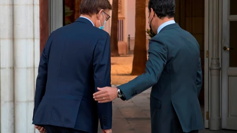 El presidente de la Junta de Andalucía, Juanma Moreno, del PP, (d), y el de la Generalitat Valenciana, Ximo Puig, del PSOE (i), tras posar ante la fachada del Palacio de San Telmo. EFE/ Raúl Caro