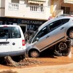 Vehículos dañados en una calle de Lepe (Huelva) tras las fuertes lluvias caídas hoy jueves en el litoral onubense