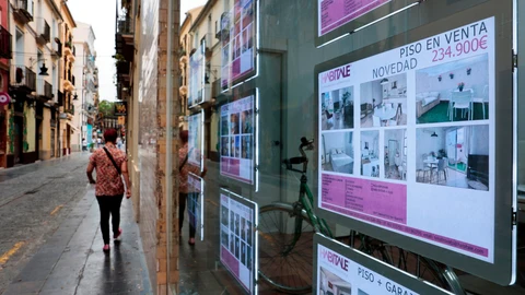 Una persona pasa ante el escaparate de una agencia inmobiliaria