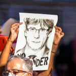 Una mujer sostiene una pancarta durante una concentración en apoyo al vicepresidente de la Generalitat, Carles Puigdemont, en la plaza de San Jaume de Barcelona