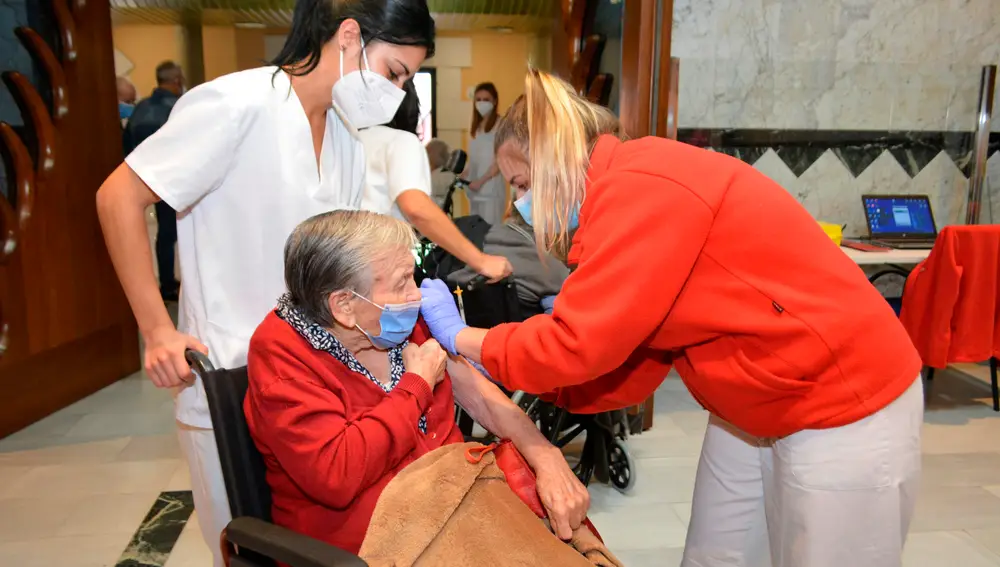 Una residente del centro Santa Eugenia de la localidad palentina de Cevico de la Torre recibe la tercera dosis de la vacuna contra la covid-19 este viernes