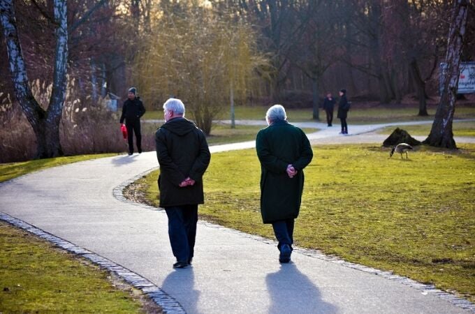 Una pareja jubilada pasea por un parque