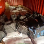 Las bolsas de deporte que contenían la droga sobre la mercancía del contenedor