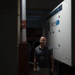 Manuel Casellas, an attorney who served as president of the Ritz condominium, poses for the camera in front of a generator bought more than a year ago at a total cost of $100,000 with the hopes that all 84 apartments could feed off it when blackouts occur, in San Juan, Puerto Rico, Thursday, Sept. 30, 2021. The residents first need a power company official to connect the generator to the grid, but officials have canceled several appointments at the last minute without explanation. (AP Photo/Carlos Giusti)