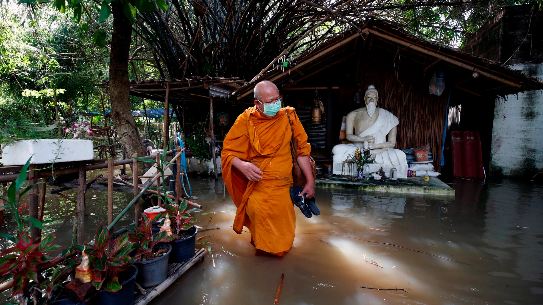 Koh Kret (Thailand), 05/10/2021.- A Thai Buddhist monk wades through floodwater at a flooded temple's monk dwelling in Koh Kret community, Nonthaburi neighboring province of Bangkok, Thailand, 05 October 2021. Flooding caused by tropical storm Dianmu has swamped 32 provinces in several parts of Thailand, killed at least eight people and more than two hundreds thousands households have been affected, according to the Disaster Prevention and Mitigation Department. (Inundaciones, Tailandia, Estados Unidos) EFE/EPA/RUNGROJ YONGRIT