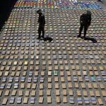 FILE - In this Thursday, Aug. 10, 2017 file photo, police officers walk among packages of seized cocaine at the Pacific port of Buenaventura, Colombia, after about one ton of cocaine was seized in a container during an operation by counternarcotics police at the port. In 2018, Capt. Juan Pablo Mosquera, a Colombian national police officer who was part of an elite unit that worked closely with U.S. anti-narcotics agents, was extradited to Miami to stand trial on charges he betrayed the U.S. Drug Enforcement Administration to the same traffickers they were jointly fighting. (AP Photo/Fernando Vergara)
