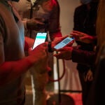 Una persona muestra un código QR para entrar a un local de ocio nocturno