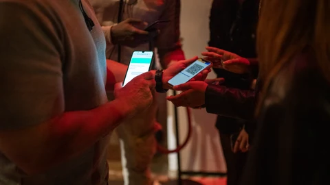 Una persona muestra un código QR para entrar a un local de ocio nocturno