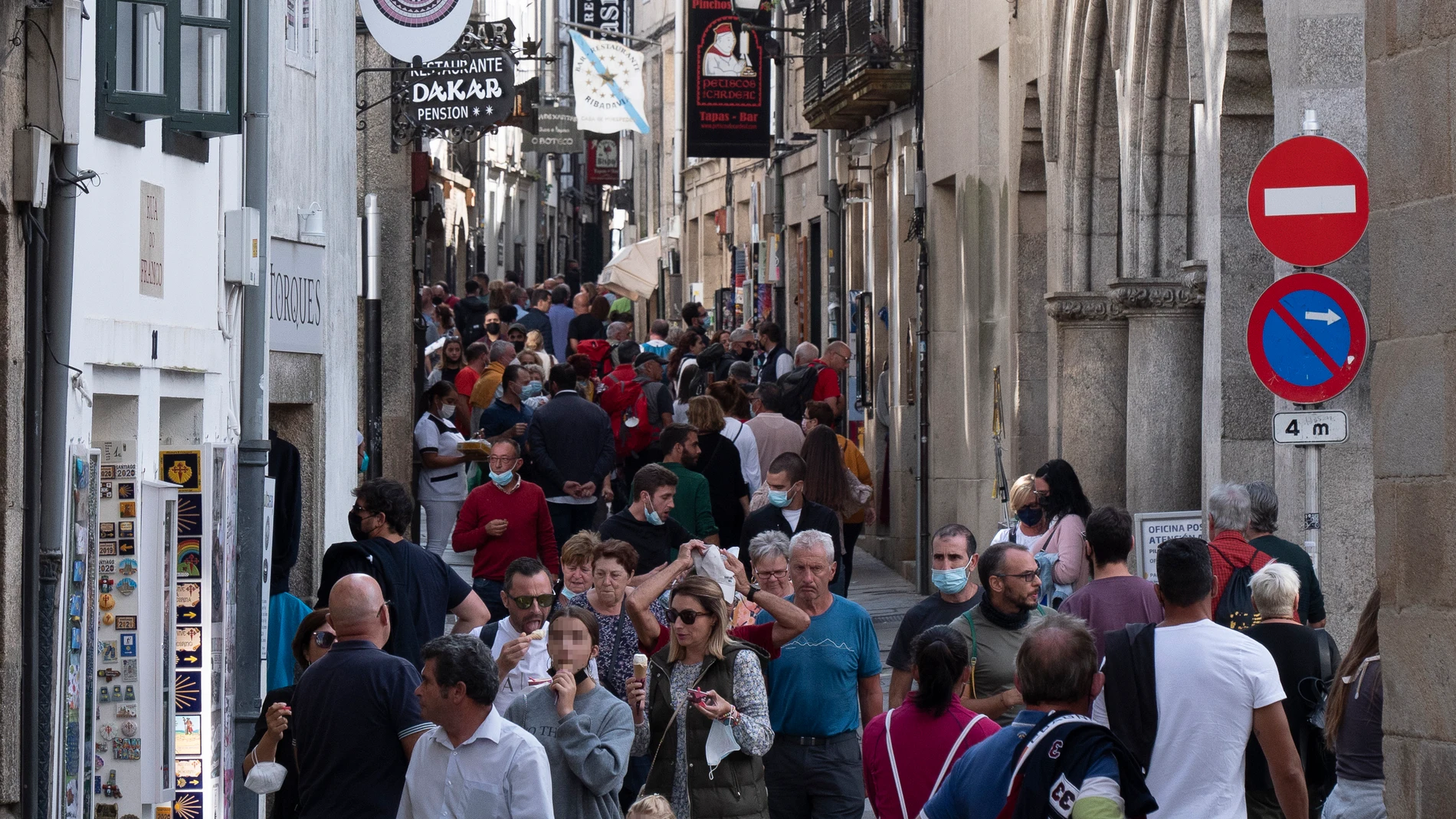 Varias personas caminan por una calle céntrica de Santiago de Compostela, en La Coruña, Galicia (España), que este fin de semana ha ampliado aforos en hostelería y reuniones