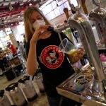 Una camarera sirve una cerveza en un bar