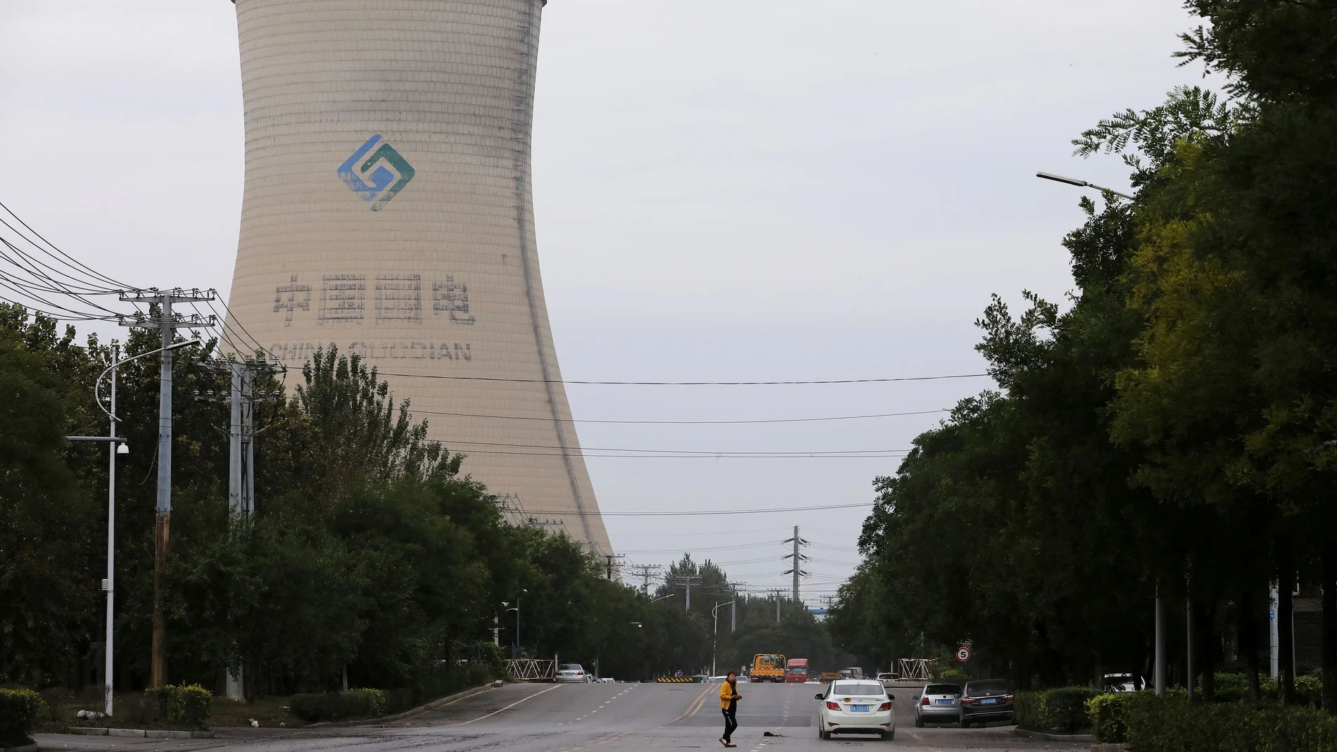 FILE PHOTO: A person walks near a China Energy coal-fired power plant in Shenyang, Liaoning province, China September 29, 2021. REUTERS/Tingshu Wang/File Photo