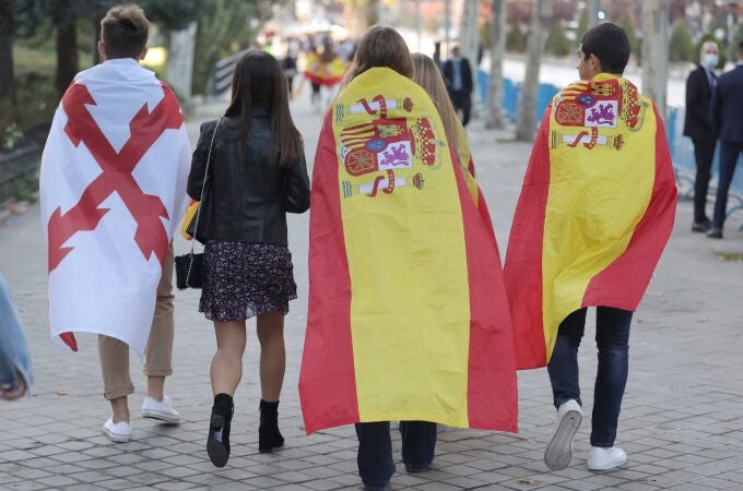 Varios jóvenes se dirigen al desfile del 12 de octubre. En la imagen se pueden distinguir dos banderas: la bandera de España, y la Cruz de Borgoña, la única posible para celebrar la Hispanidad | Fuente: Eduardo Parra / Europa Press