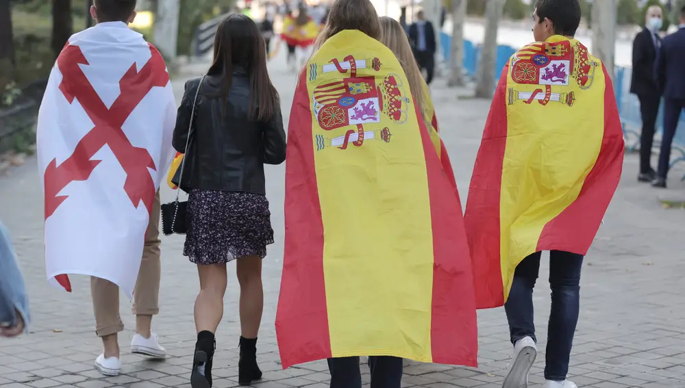 Varios jóvenes se dirigen al desfile del 12 de octubre. En la imagen se pueden distinguir dos banderas: la bandera de España, y la Cruz de Borgoña, la única posible para celebrar la Hispanidad | Fuente: Eduardo Parra / Europa Press