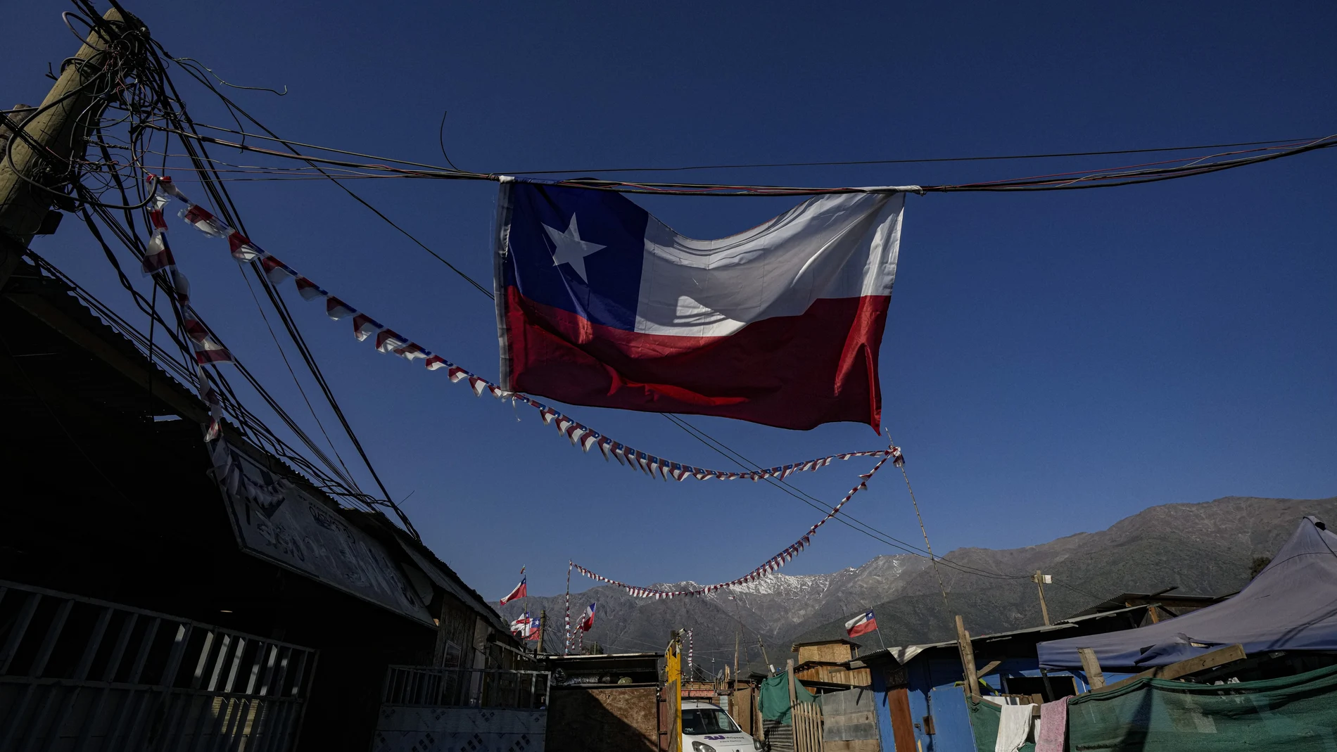A Chilean flag hangs inside a camp where migrants from Haiti, Peru and Colombia, set up a homes and call "Dignidad," or Dignity, in Santiago, Chile, Thursday, Sept. 30, 2021. There are 180,000 Haitians in Chile, of whom â€œalmost 70,000 reside in the country permanently,â€ said deputy interior minister Juan Francisco Galli. (AP Photo/Esteban Felix)