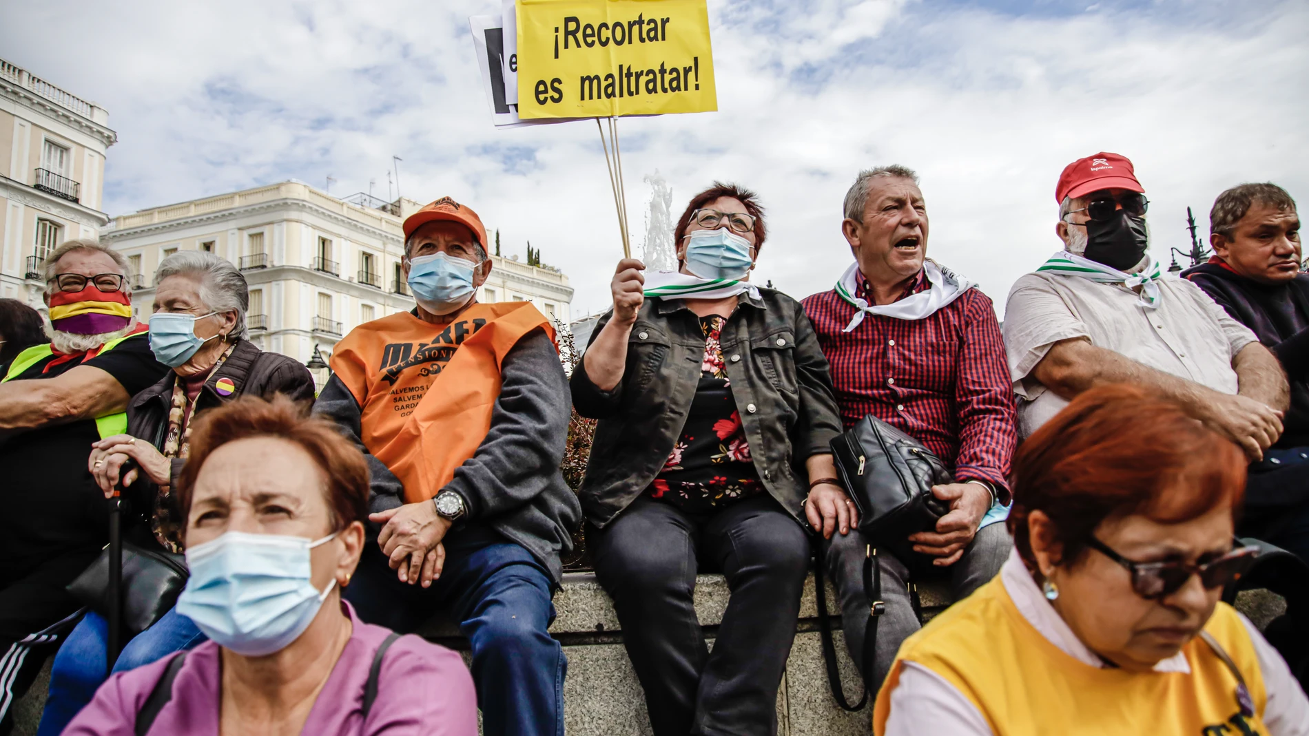 Una mujer con un cartel en el que se lee: 'Recortar es maltratar', participan en una concentración de pensionistas en la Puerta del So