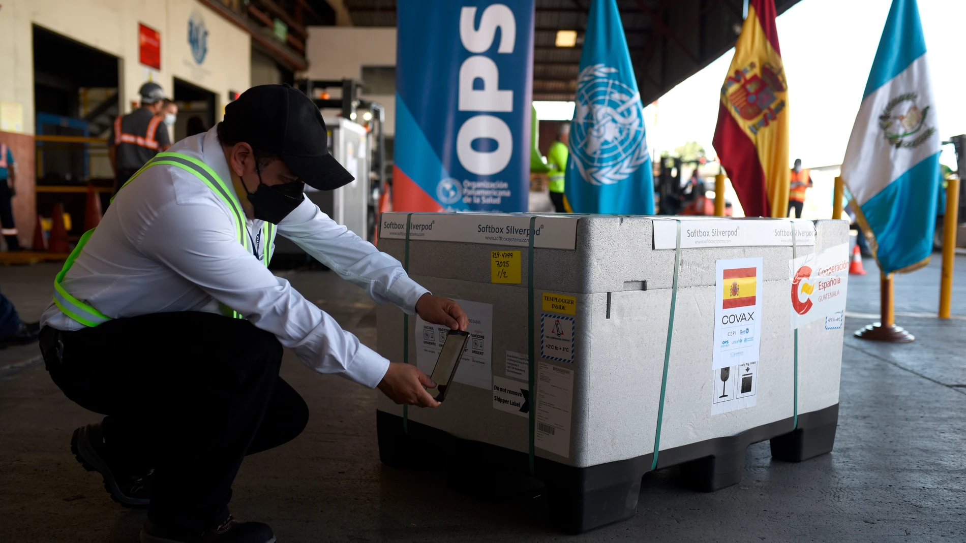 Un empleado del Aeropuerto Internacional La Aurora toma una fotografía a un lote de vacuna entregadas por España