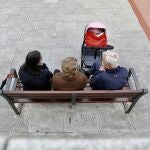 Varios pensionistas charlan sentados en un banco