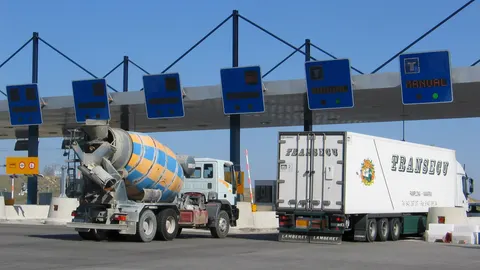 Dos camiones cruzan las cabinas de una carretera de peaje