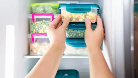 En la imagen, varios recipientes con comida congelada