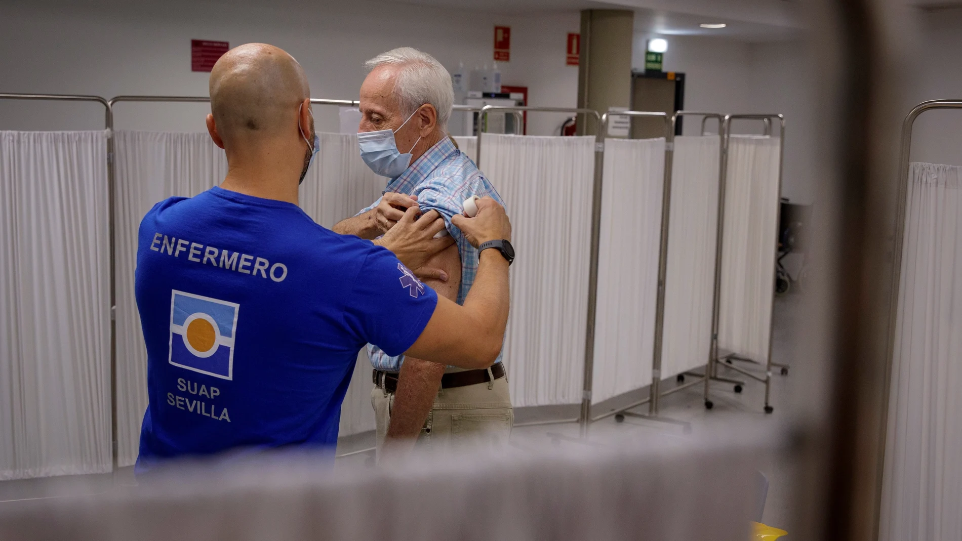 Un enfermero inocula la tercera dosis de la vacuna contra la covid-19 a un hombre mayor de 70 años en Sevilla. EFE/ Julio Muñoz
