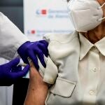 Una mujer se vacuna de la gripe y la covid-19 este lunes en Madrid, cuando se comienza a administrar la dosis de refuerzo de la covid-19 a los mayores de 70 años
