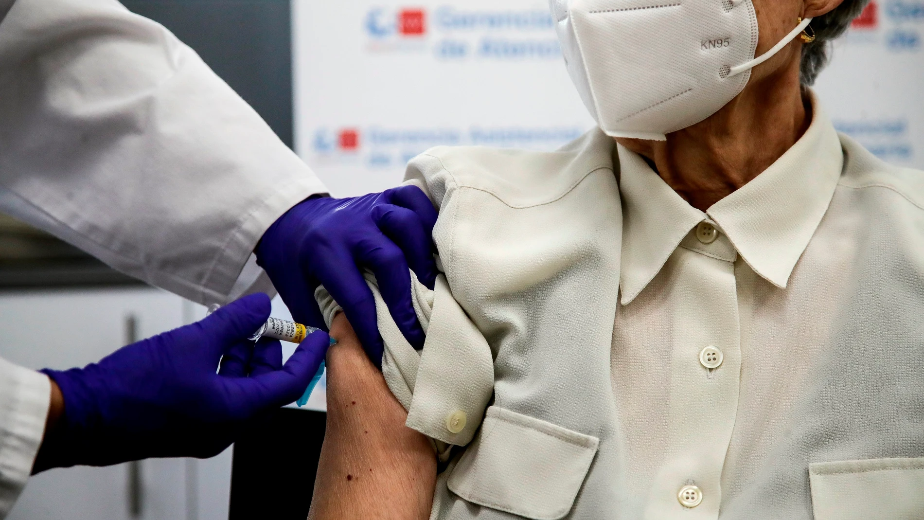 Una mujer se vacuna de la gripe y la covid-19 este lunes en Madrid, cuando se comienza a administrar la dosis de refuerzo de la covid-19 a los mayores de 70 años