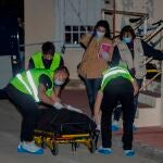 Varios trabajadores de una funeraria trasladan el cuerpo de un hombre de 53 años, apuñalado de muerte por su hijo este lunes en Campos del Río