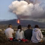 Cuatro residentes de La Palma contemplan el volcán que sigue en erupción tras 39 días. (AP Photo/Emilio Morenatti)