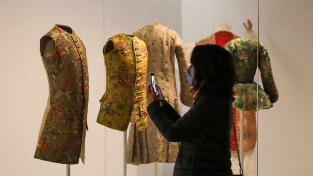 Una persona fotografía una de las prendas de la reinauguración del Museo del Traje, a 27 de octubre de 2021, en Madrid, (España).