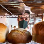 Domi Vélez muestra alguno de los panes que fabrican en su panadería de la calle Suecia, en la localidad sevillana de Lebrija
