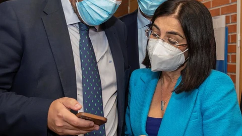 El presidente de la Comunidad de Murcia, Fernando López Miras (i), enseña su móvil a la ministra de Sanidad, Carolina Darias, en presencia del consejero de Salud de Murcia, Juan José Pedreño, este jueves durante la visita al hospital Virgen de la Arrixaca de Murcia.