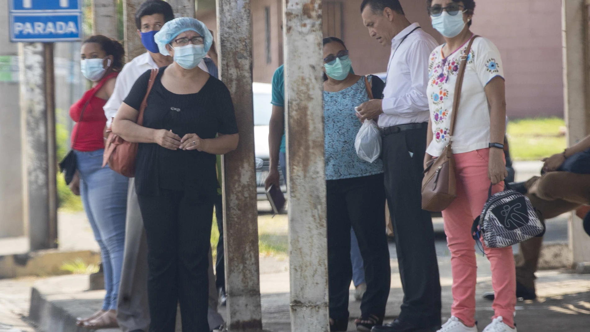 AME3092. MANAGUA (NICARAGUA), 29/10/2021.- Personas con y sin tapabocas esperan hoy para tomar el autobús en Managua (Nicaragua). Nicaragua se encuentra a un poco más de una semana de las elecciones generales en medio de la pandemia por la covid-19, una enfermedad que ha generado debate por el contraste entre las cifras oficiales y la de médicos independientes, y por una vacunación a cuenta gotas que ha llevado a miles de nicaragüenses a cruzar la frontera, principalmente a la vecina Honduras, en busca de la inyección. EFE/Jorge Torres