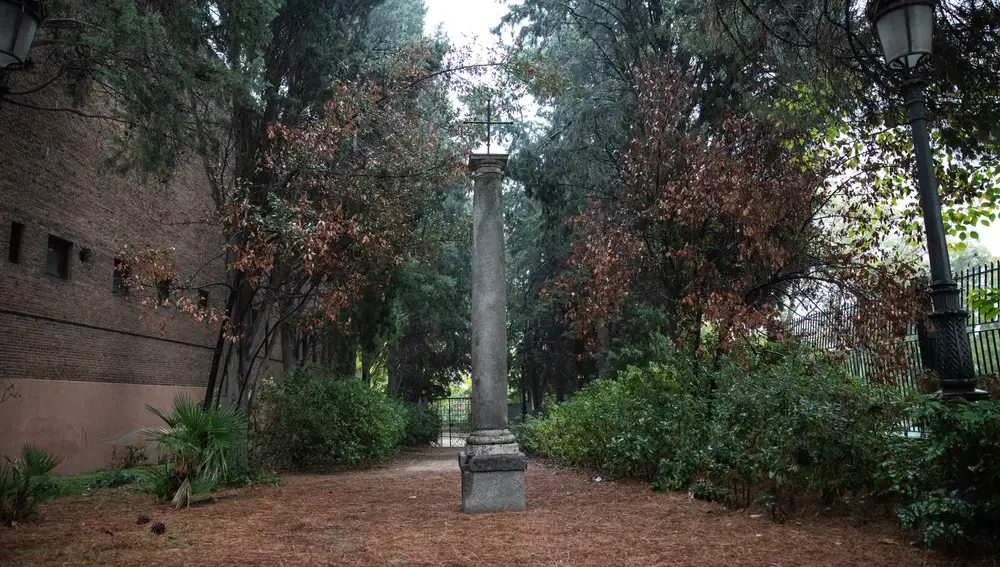 Cruz de hierro sobre la columna pétrea que da acceso al cementerio.