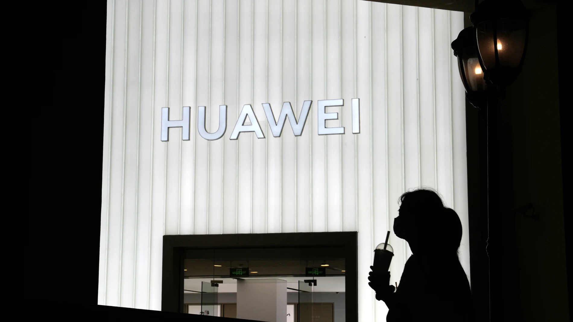 Una mujer pasa por delante de una tienda de Huawei en Pekín