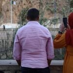 Familiares y personas curiosas saludan a los argelinos en la zona de Bin Lajraf. Una madre rompe a llorar al ver a su hija que le saluda moviendo la mano desde lejos, bajo la mirada de Hasan, vendedor ambulante de café y testigo de historias que se repiten cada día.