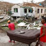BOG402. PROVIDENCIA (COLOMBIA), 03/11/2020.- Fotografía de archivo del 21 de noviembre de 2020 que muestra a dos hombres mientras cargan un sofá frente a una casa destruida en medio de los escombros que dejó el paso del huracán Iota, en la isla de Providencia, Archipiélago de San Andrés (Colombia). La posición geográfica de Colombia, con costas en el Atlántico y el Pacífico, y los altos índices de deforestación, hacen del país uno de los más vulnerables al cambio climático, por lo cual el Gobierno defiende en Glasgow incentivos económicos de la comunidad internacional para las inversiones en "acción climática estructural". EFE/ Mauricio Dueñas Castañeda ARCHIVO