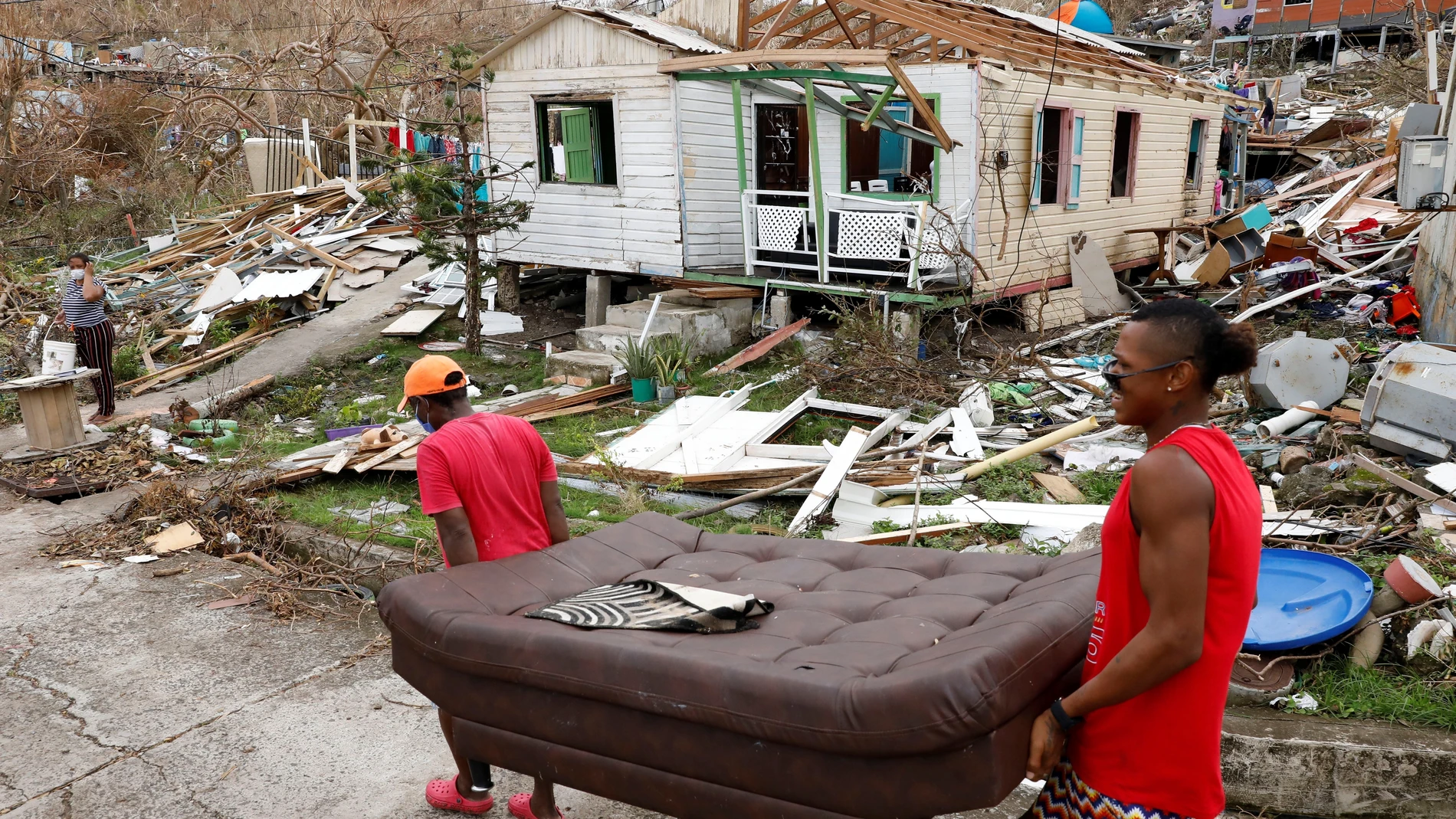 BOG402. PROVIDENCIA (COLOMBIA), 03/11/2020.- Fotografía de archivo del 21 de noviembre de 2020 que muestra a dos hombres mientras cargan un sofá frente a una casa destruida en medio de los escombros que dejó el paso del huracán Iota, en la isla de Providencia, Archipiélago de San Andrés (Colombia). La posición geográfica de Colombia, con costas en el Atlántico y el Pacífico, y los altos índices de deforestación, hacen del país uno de los más vulnerables al cambio climático, por lo cual el Gobierno defiende en Glasgow incentivos económicos de la comunidad internacional para las inversiones en "acción climática estructural". EFE/ Mauricio Dueñas Castañeda ARCHIVO