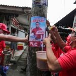 Simpatizantes de Walter Espinoza colocan carteles de uno de los candidatos presidenciales autorizados por el régimen para simular unas elecciones democráticas en Nicaragua